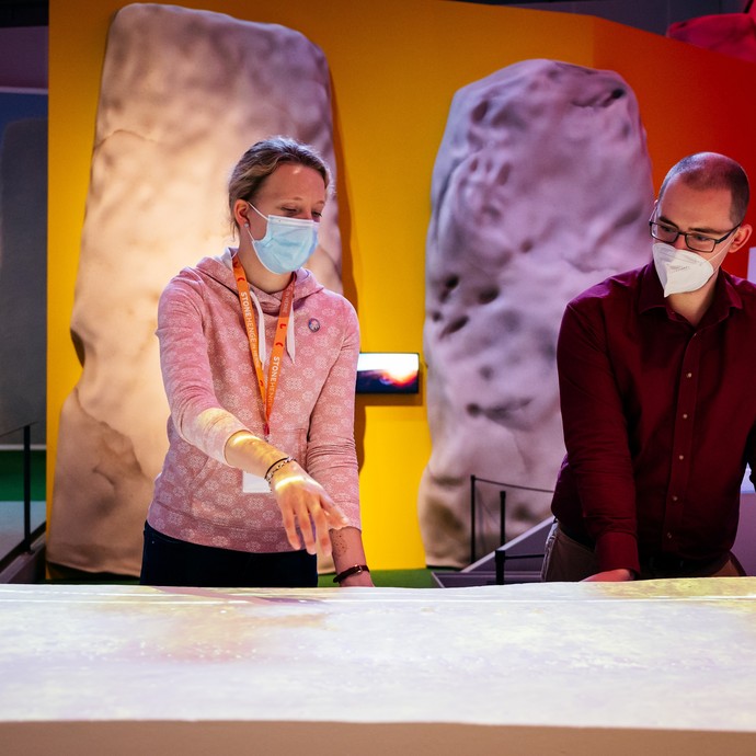Zwei Besucher:innen vor dem 3-D-Modell in der Ausstellung (öffnet vergrößerte Bildansicht)